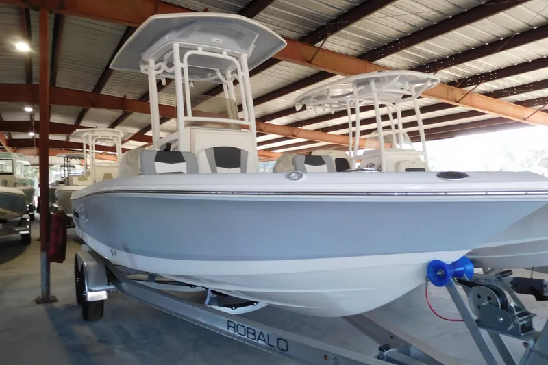 Slide: The Image of 2026 Robalo 226 Cayman boat in showroom, featuring sleek design and modern features. - 2