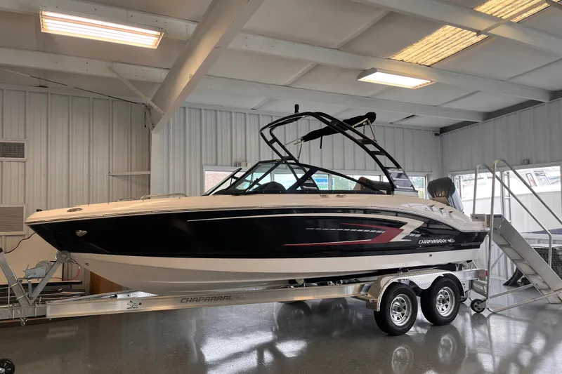 The Image of 2025 Chaparral 21 SSi OB boat on trailer in indoor showroom. - 0