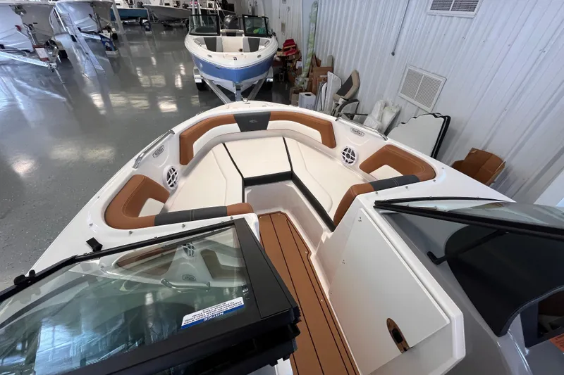Slide: The Image of 2025 Chaparral 21 SSi OB boat interior with tan seating in showroom. - 7