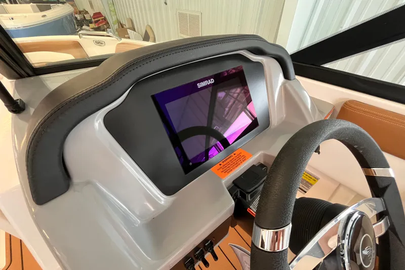 Slide: The Image of 2025 Chaparral 21 SSi OB boat dashboard with Simrad display and steering wheel. - 9