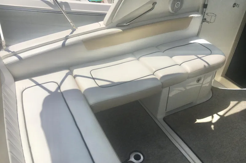 Slide: The Image of 2010 Sea Ray 260 Sundancer interior with cushioned seating and carpeted flooring. - 11