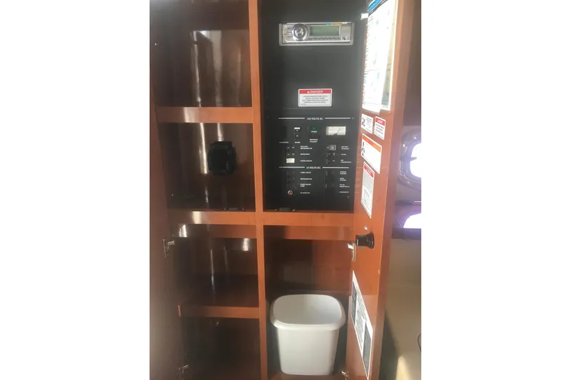 Slide: The Image of 2010 Sea Ray 260 Sundancer interior control panel with wooden cabinetry and storage. - 20