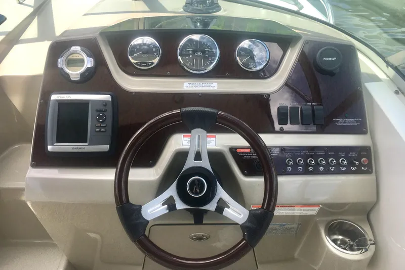 Slide: The Image of Dashboard of a 2010 Sea Ray 260 Sundancer boat with steering wheel and controls. - 6