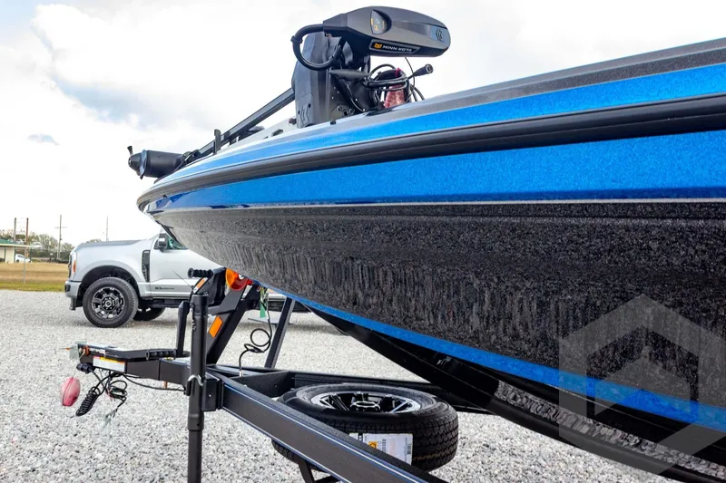 Slide: The Image of 2026 Skeeter ZXE21 boat on trailer, blue hull, parked beside a truck. - 16