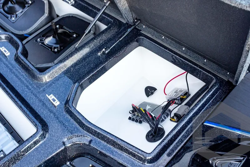 Slide: The Image of Open storage compartment in 2026 Skeeter ZXE21 boat, showing wiring and equipment. - 38