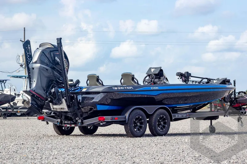 Slide: The Image of 2026 Skeeter ZXE21 boat with dual console, blue and black design, on a trailer. - 4