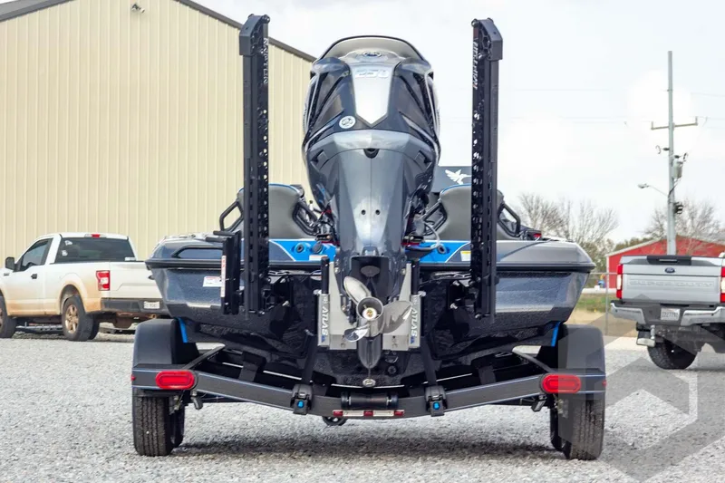 Slide: The Image of 2026 Skeeter ZXE21 boat on trailer, rear view, parked on gravel near trucks. - 5