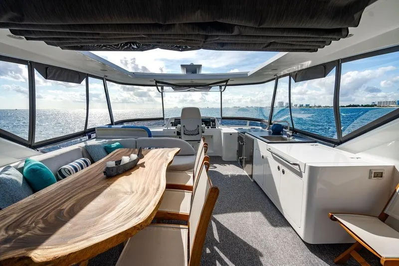 Slide: The Image of Luxurious Lanzarote Ventuno 73 yacht interior with ocean view, featuring elegant seating and wooden table. - 38