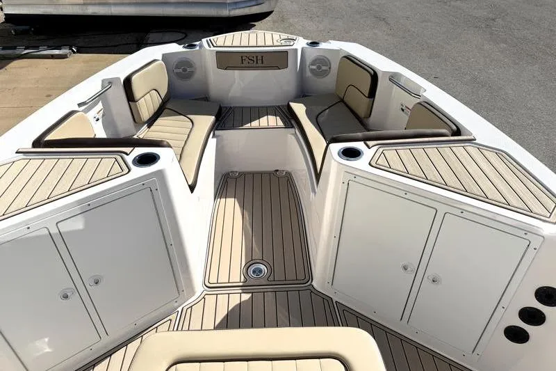 Slide: The Image of 2024 Yamaha Boats 222 FSH Sport interior with cushioned seating and storage compartments. - 14