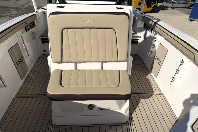 Slide: The Image of 2024 Yamaha Boats 222 FSH Sport interior with beige seating and sleek design. - 18