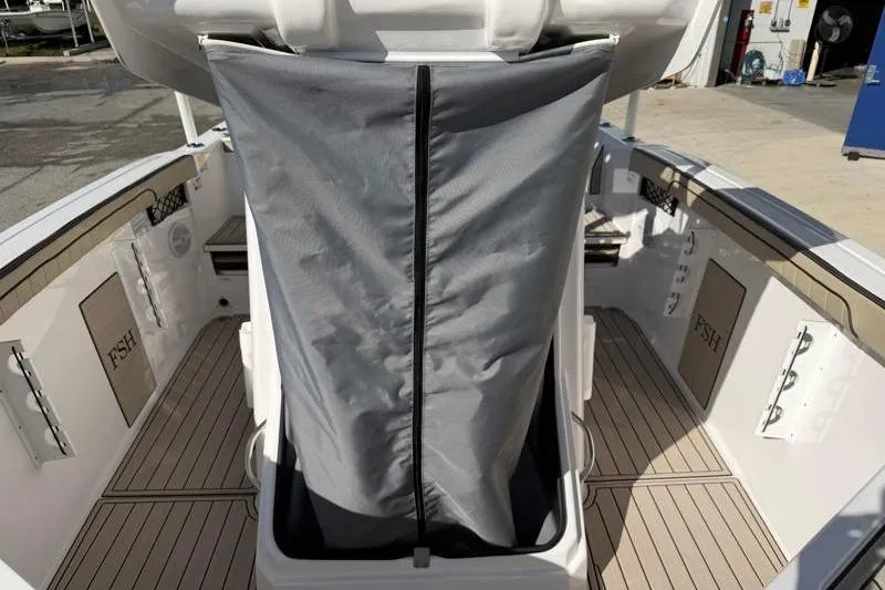 Slide: The Image of 2024 Yamaha Boats 222 FSH Sport interior with covered console and deck view. - 19