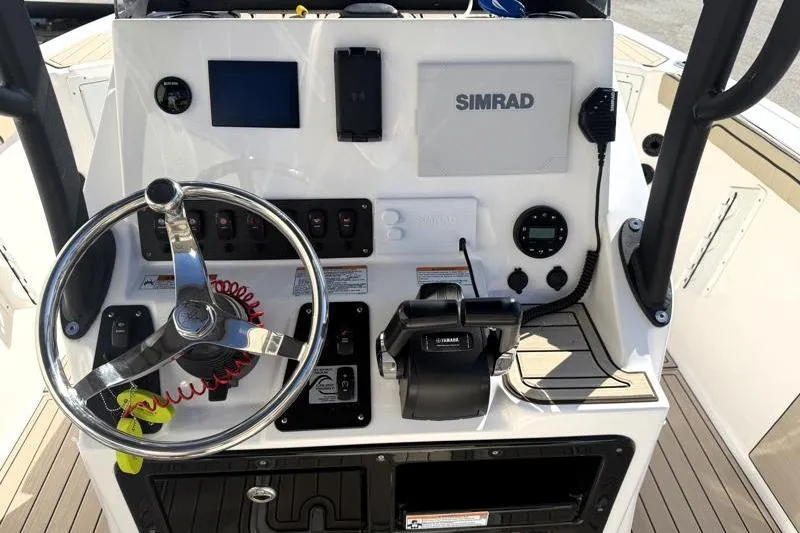 Slide: The Image of 2024 Yamaha Boats 222 FSH Sport dashboard with steering wheel and Simrad electronics. - 29