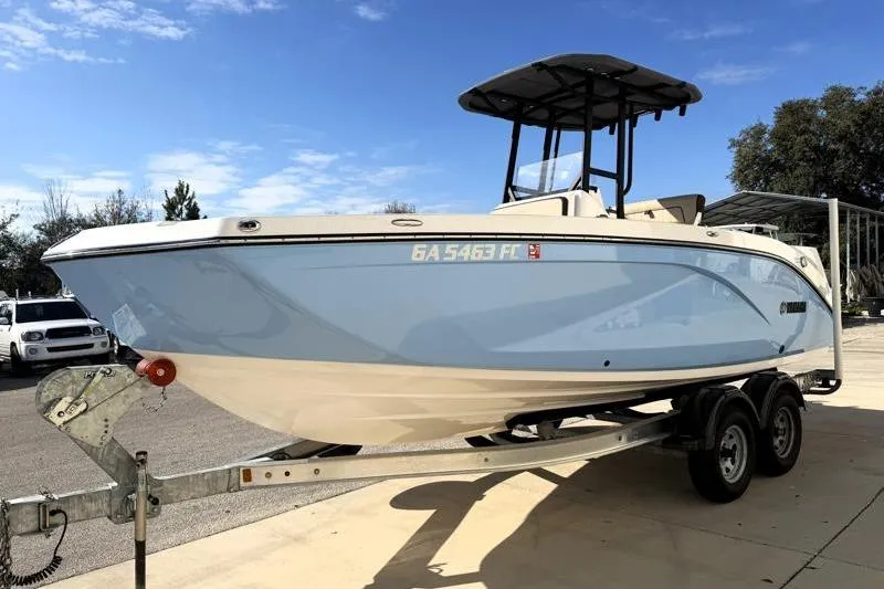 Slide: The Image of 2024 Yamaha Boats 222 FSH Sport on trailer, light blue hull, sunny day. - 3