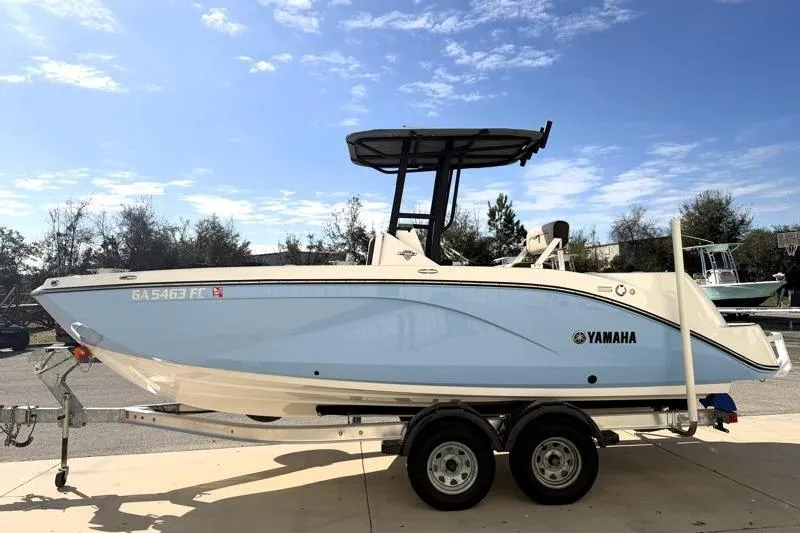 Slide: The Image of 2024 Yamaha Boats 222 FSH Sport on trailer, side view under clear sky. - 4