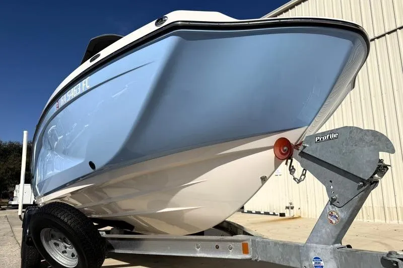 Slide: The Image of 2024 Yamaha Boats 222 FSH Sport on trailer, light blue hull, parked outdoors. - 8