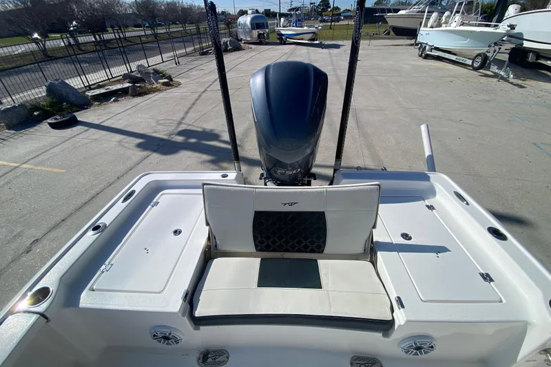 Slide: The Image of 2023 Tidewater 2410 Bay Max boat on trailer, displayed outdoors with American flag. - 12
