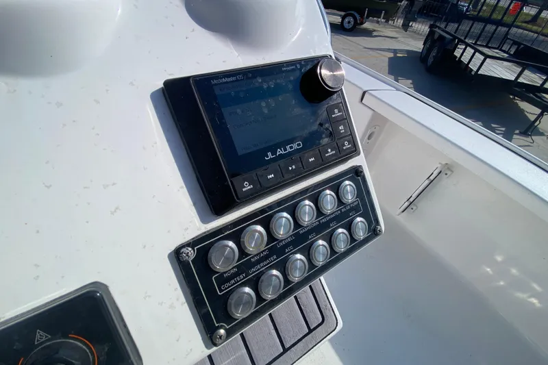 Slide: The Image of 2023 Tidewater 2410 Bay Max boat interior with seating and controls, docked under a modern canopy. - 18