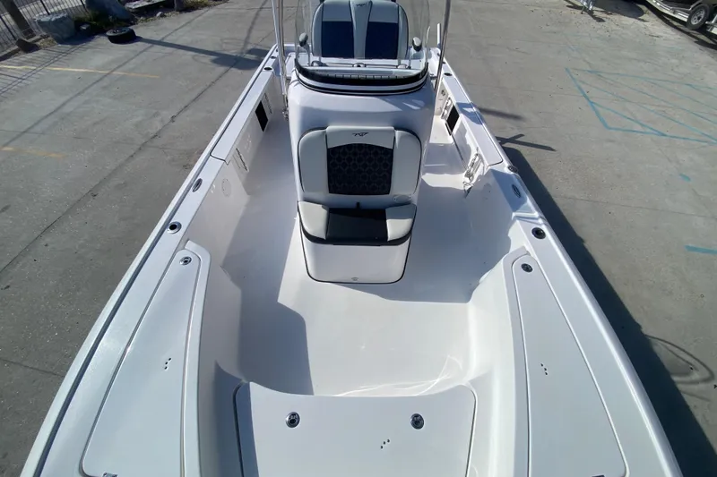 Slide: The Image of 2023 Tidewater 2410 Bay Max boat interior at a dealership with trucks in the background. - 23