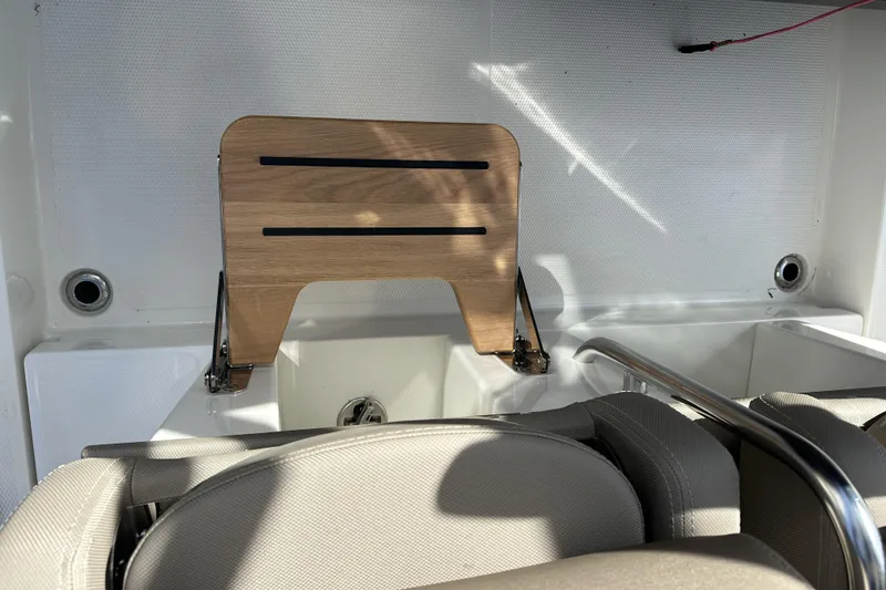 Slide: The Image of 2024 Nimbus T-8 boat interior with wooden foldable table and cushioned seating. - 2