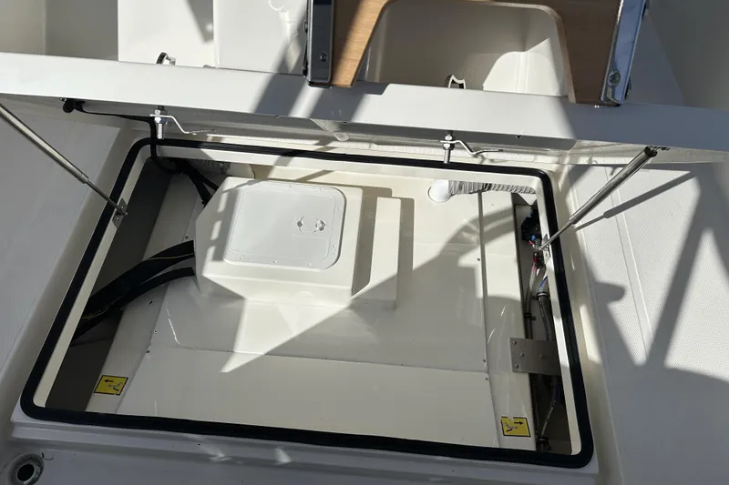Slide: The Image of Open storage compartment in 2024 Nimbus T-8 boat, featuring hydraulic struts and secure latches. - 5