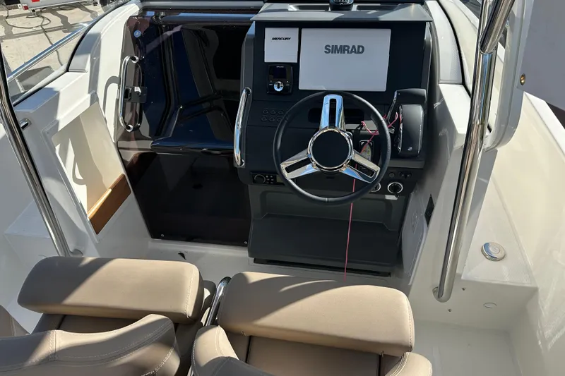 Slide: The Image of 2024 Nimbus T-8 boat cockpit with steering wheel and Simrad navigation system. - 9