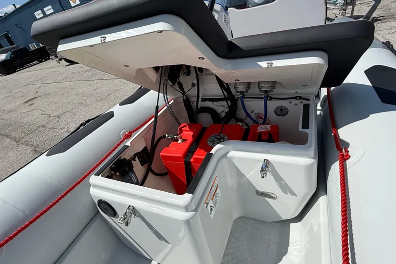 Slide: The Image of 2026 Zodiac Open 4.2 boat showing open storage compartment with red fuel tank. - 5
