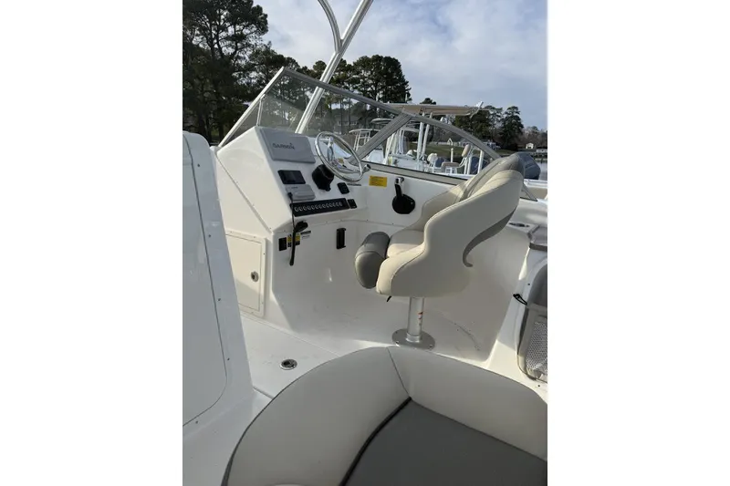 Slide: The Image of 2026 Key West 239 DFS boat interior with steering console and seating. - 6