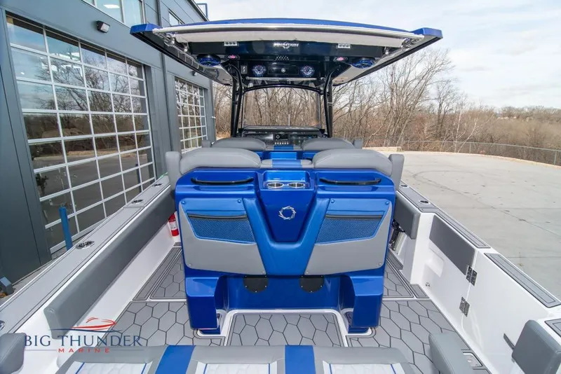 Slide: The Image of 2022 Fountain 38 SC boat interior with gray and blue seating, illuminated floor, and powerful engines. - 16