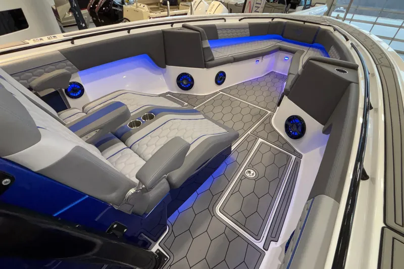 Slide: The Image of 2022 Fountain 38 SC boat interior with modern seating, blue LED lighting, and hexagonal flooring. - 69