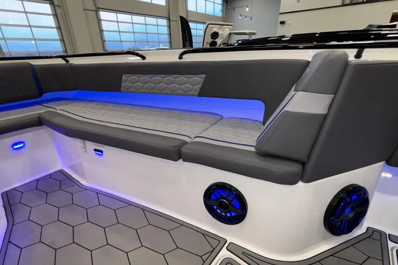 Slide: The Image of 2022 Fountain 38 SC boat interior with gray seating, blue LED lighting, and hexagonal flooring. - 75