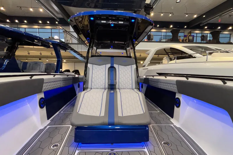 Slide: The Image of 2022 Fountain 38 SC boat interior with modern seating and ambient blue lighting. - 76