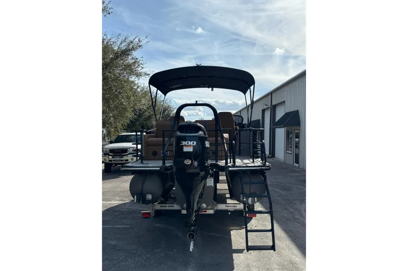 Slide: The Image of 2026 Starcraft RX 23 Q DH boat with 300 HP engine, parked outdoors. - 6