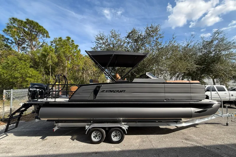 Slide: The Image of 2026 Starcraft RX 23 Q DH pontoon boat on trailer, parked outdoors. - 8