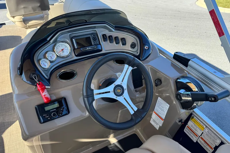 Slide: The Image of 2023 Sun Tracker Fishin' Barge 20 DLX dashboard with steering wheel and controls. - 17