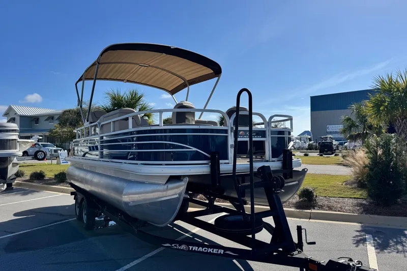 Slide: The Image of 2023 Sun Tracker Fishin' Barge 20 DLX pontoon boat on trailer, sunny day. - 3
