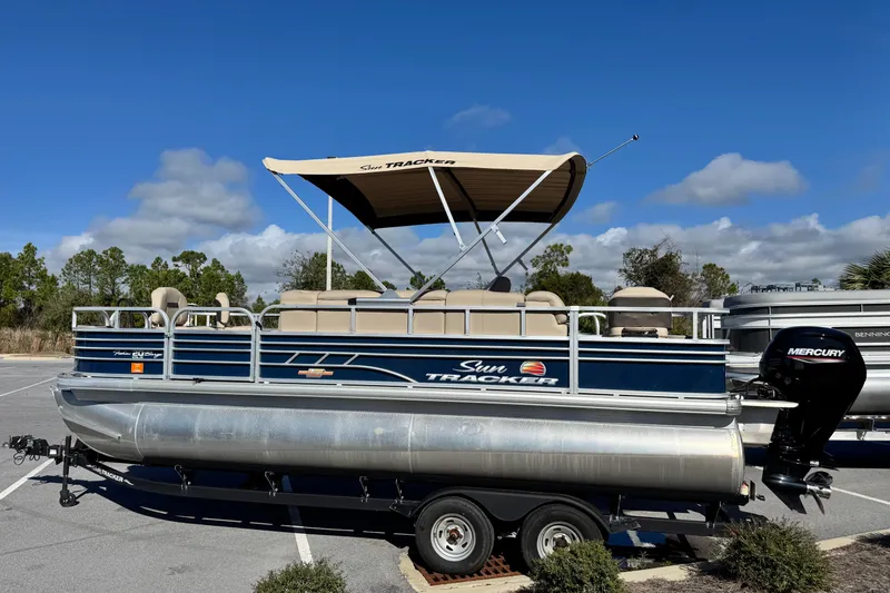 Slide: The Image of 2023 Sun Tracker Fishin' Barge 20 DLX pontoon boat with canopy, parked outdoors. - 8