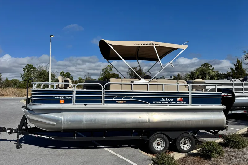 Slide: The Image of 2023 Sun Tracker Fishin' Barge 20 DLX pontoon boat parked under clear blue sky. - 9