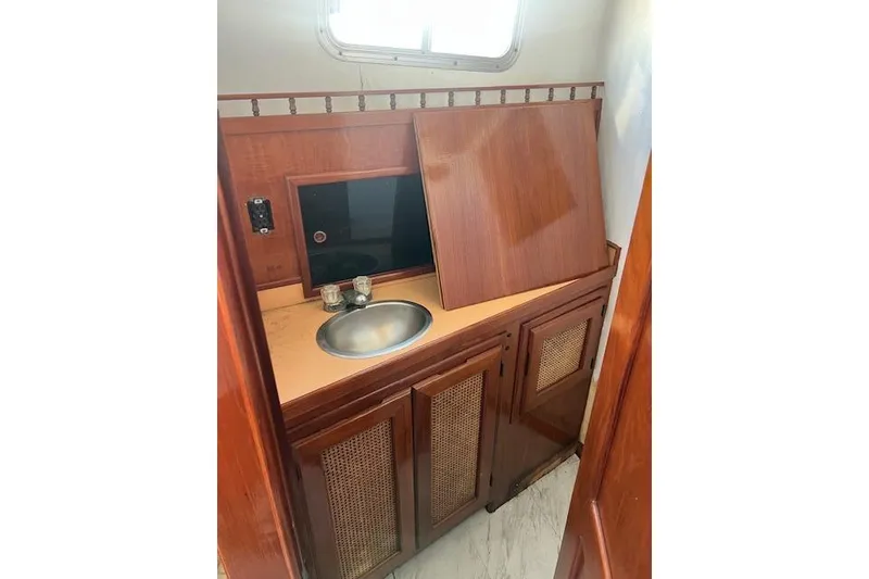 Slide: The Image of 1985 Sunnfjord 40 boat interior with wooden cabinetry and small sink. - 18