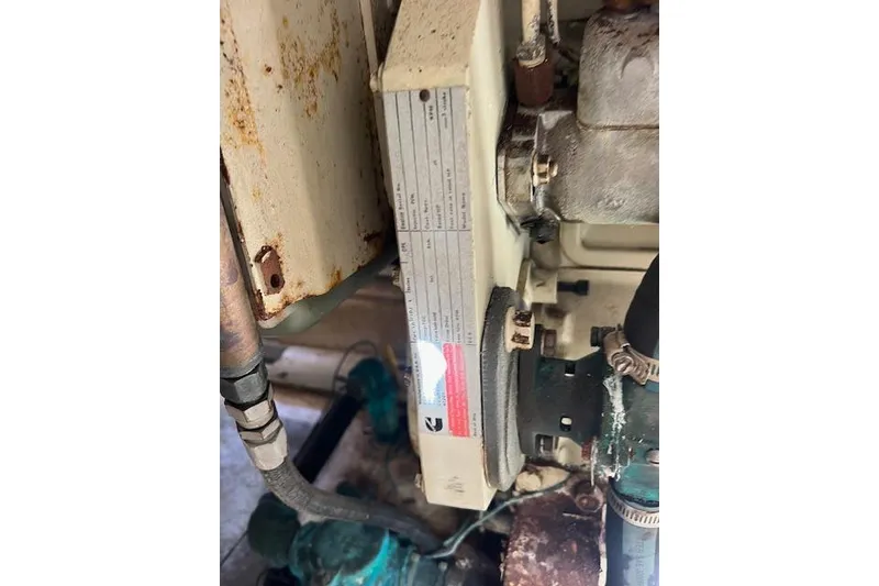 Slide: The Image of Engine compartment of a 1985 Sunnfjord 40, showing mechanical components and rust. - 28