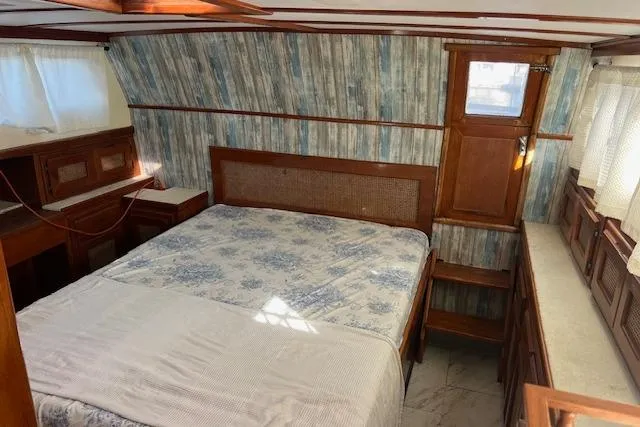Slide: The Image of Cozy cabin interior of 1985 Sunnfjord 40 boat with wood accents and patterned wallpaper. - 9