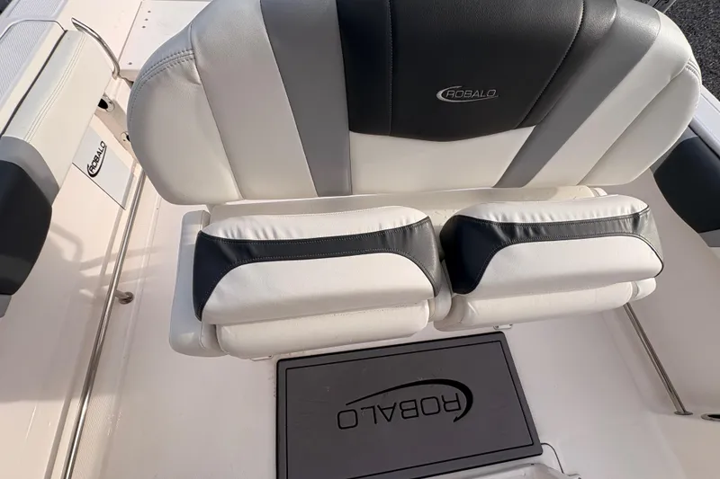 Slide: The Image of 2023 Robalo R230 Center Console boat seating with logo, featuring white and black upholstery. - 16