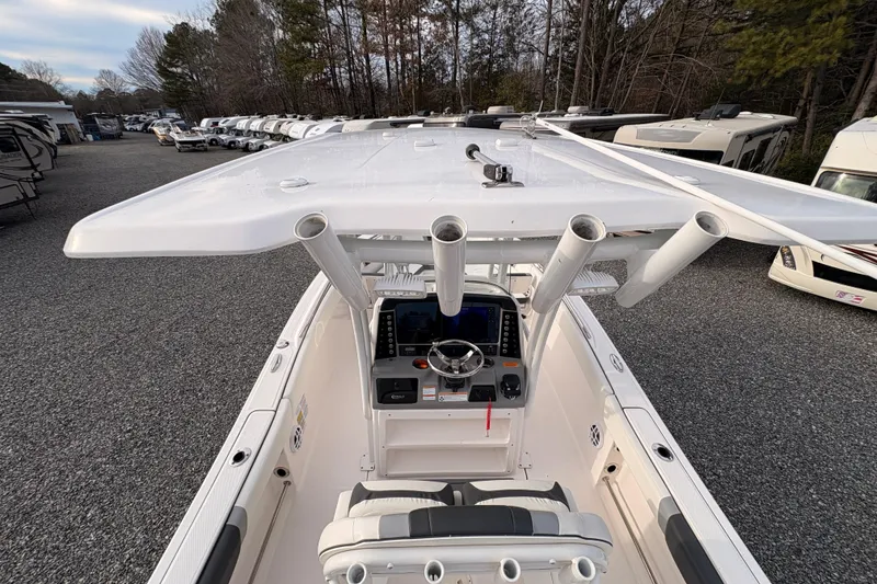 Slide: The Image of 2023 Robalo R230 Center Console boat with helm and rod holders, parked outdoors. - 17