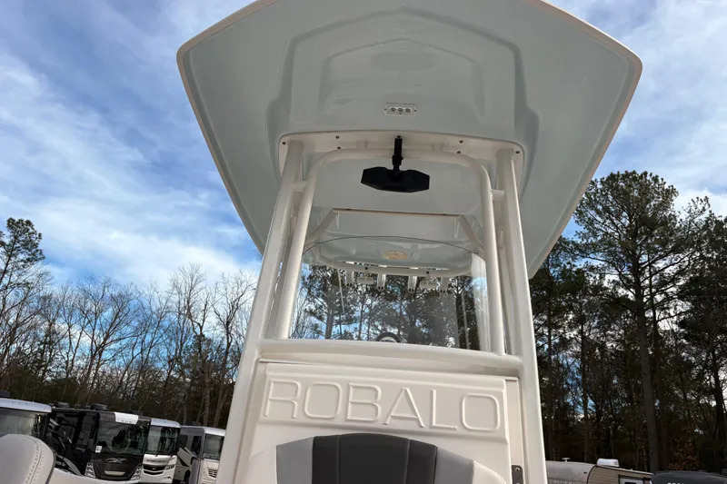 Slide: The Image of 2023 Robalo R230 Center Console boat with T-top against a blue sky backdrop. - 8