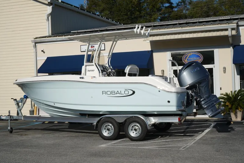 The Image of 2026 Robalo R202 Explorer boat on trailer outside a building. - 0