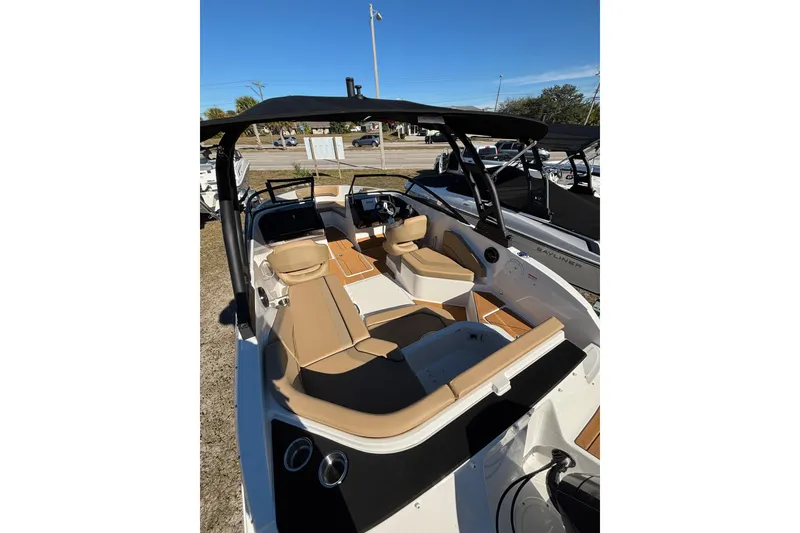 Slide: The Image of 2026 Bayliner V20 boat interior with tan seating and black canopy. - 11