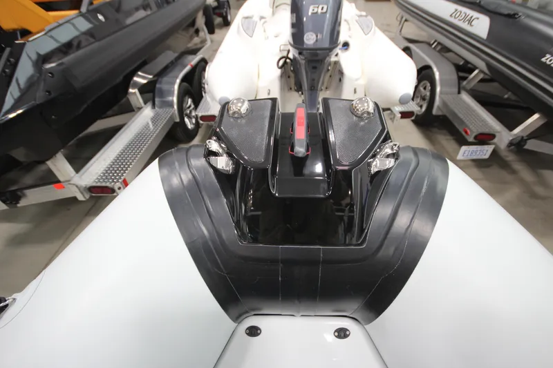 Slide: The Image of 2026 Zodiac Open 4.2 boat with motor, displayed on a trailer in a showroom. - 19