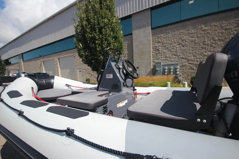 Slide: The Image of Zodiac Open 4.2 NEO 50hp boat, 2026 model, parked outside a building. - 4