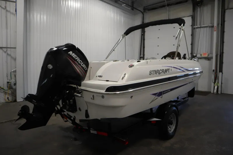 Slide: The Image of 2015 Starcraft 1915 OB Limited boat with Mercury outboard motor in a garage setting. - 5