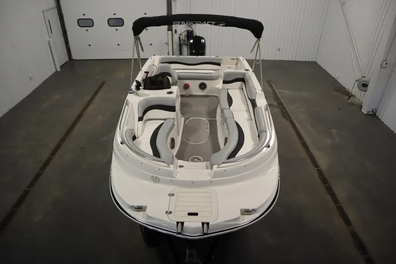 Slide: The Image of 2015 Starcraft 1915 OB Limited boat in a garage, showcasing seating and interior layout. - 9