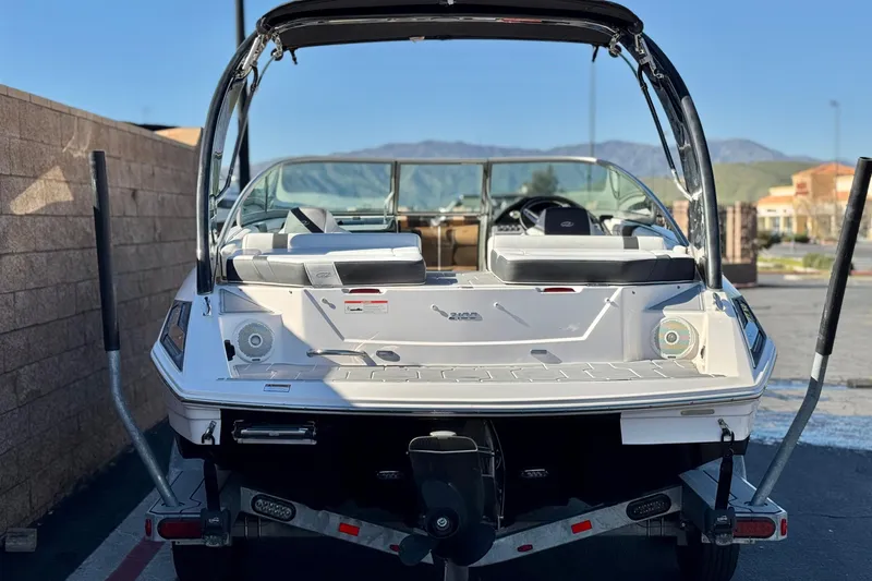 Slide: The Image of 2019 Regal 2100 boat on trailer, rear view, parked outdoors. - 4